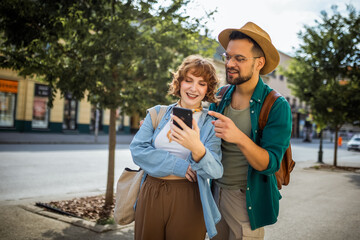 Wall Mural - Young couple, on a vacation, exploring the new city and using their phone as gps to help them not get lost.