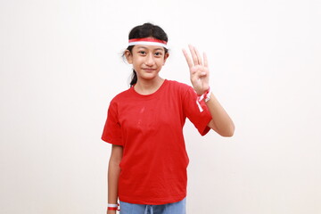 Asian young girl with red white ribbon for celebrating Indonesia independence day standing while showing four fingers