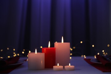 Wall Mural - Burning candles on table indoors. Bokeh effect