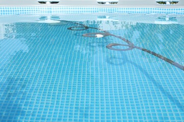 Poster - One robotic cleaner with pipe in swimming pool outdoors