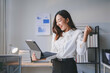 © amnaj - Young asian businesswoman is holding a tablet and celebrating success in the office