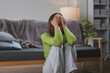 © amnaj - Sad young woman is sitting on the floor by the sofa, covering her face and crying