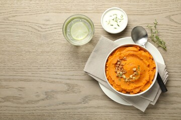 Wall Mural - Delicious mashed sweet potatoes served on wooden table, top view. Space for text