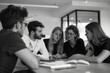 © Tanu - Four colleagues seated at a table, each with a laptop, collaborating on a project in a professional setting, A group of colleagues discussing ideas around a table. AI generated