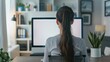 © IR-Creative - A young woman is seen using a computer in front of a blank white screen at home.