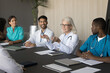 © fizkes - Group of doctors, diverse interns listen older woman therapist, hospital chief, make speech, provide information, gathered together for decision making, discuss patient treatment plan. Medical seminar