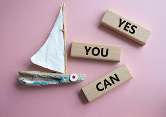 Wall Mural - Yes You Can symbol. Concept word Yes You Can on wooden blocks. Beautiful pink background with boat. Business and Yes You Can concept. Copy space.