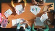 © InfiniteFlow - Top down view of start up business team holding paper while discussing about financial idea. Aerial view of smart diverse people brainstorming idea while looking at stock market statistic. Symposium.