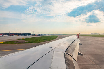 Wall Mural - View of airplane wing, blue skies and green land during landing. Airplane window view.