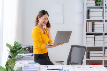 confident businesswoman on the phone: a professional woman in a yellow sweater, stands at her desk, 