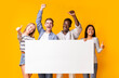 © Prostock-studio - Joyful multiracial teenagers with empty billboard showing thumbs up over yellow background