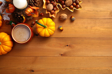 Wall Mural - Autumn flat lay composition with pumpkins, coffee cup, nuts, acorns, candle on wooden surface. Autumn, fall, Thanksgiving concept. Top view.