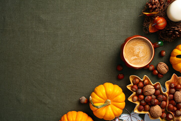 Wall Mural - Autumn flat lay composition. Flat lay pumpkins, nuts in leaf-shaped plate, coffee cup, candle, acorns on green cloth table. Vintage style. Fall, Thanksgiving concept.