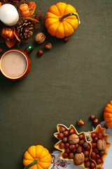 Wall Mural - Autumn fall background with pumpkins, nuts, leaves, coffee cup, candle on vintage green textile