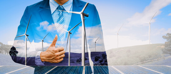 Wall Mural - Double exposure graphic of business people working over wind turbine farm and green renewable energy worker interface. Concept of sustainability development by alternative energy. uds