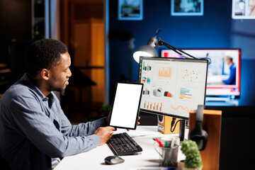 Poster - Business advisor calculates target value and annual sales, using tablet with white screen template. African american manager looking at online statistics and financial diagrams, remote work.