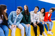 © Xavier Lorenzo - Young group of happy student friends having fun hanging out together sitting outside. Youth community concept