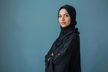 Confident arabian asian muslim woman in abaya hijab, studio portrait on blue background