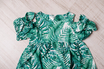 A green dress with a palm leaf pattern for toddlers, beautifully designed for a stylish and comfortable summer outfit.