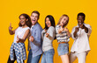 © Prostock-studio - Hey there. Cheerful group of international students indicating at camera over yellow background, pointing with fingers