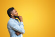 © Prostock-studio - Let me think about it. Profile portrait of thoughtful african american guy on yellow studio background with copy space, panorama