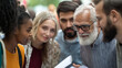 © Shahazadi - Group of diverse individuals engaged in a discussion outdoors during a community event