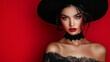 © Another Dimension - beautiful lady in witch costume for Halloween on red background with copy space