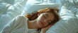 © AstraNova - Close-up of beautiful woman's face sleeping soundly on white pillow and white mattress against neutral sunlight background in the morning