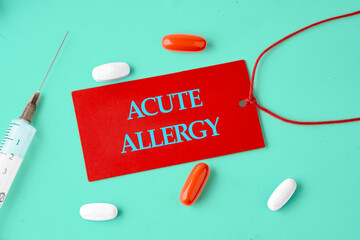 ACUTE ALLERGY words on a red card in a composition with tablets, vitamins and a syringe.