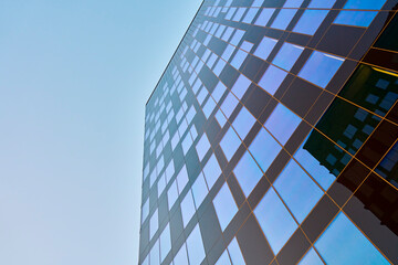 Wall Mural - Modern office building exterior with facade made of steel and glass reflecting blue sky. Contemporary architectural design