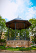 Elegant centerpiece of Morelia's plaza: The picturesque kiosk stands proudly, adorned with intricate ironwork, surrounded by vibrant greenery and historic colonial architecture.