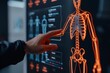 © ThamDesign - A close-up of a hand interacting with a digital skeleton model on a screen, showcasing advanced technology in anatomy research.