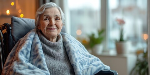 Wall Mural - A woman in a wheelchair is sitting in a chair with a blanket draped over her. She is smiling and she is happy