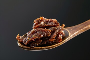 Canvas Print - A few marinated dried meat pieces on a spoon for snacking with beer