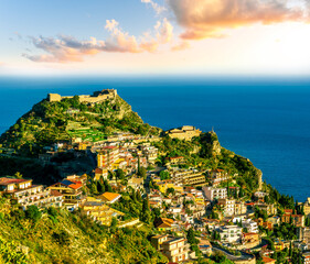 scenic view at beautiful mountain town on a sea coast in Italy with green hills, antique buildings and amazing blue sea on backgeound of landscape