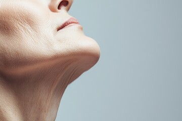 aging saggy skin on a woman's neck, with copy space. Soft, natural lighting. Simple, neutral background