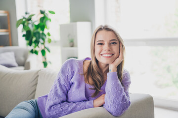 Photo of attractive young woman sit couch dreamy have rest dressed purple outfit cozy day light home interior living room