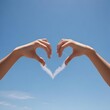 © Aaron - Self acceptance, learning to love yourself in the form of a person's hands forming a heart shape against a blue sky