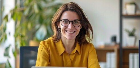 Wall Mural - A woman wearing glasses and a yellow shirt is smiling at the camera