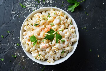 Poster - Homemade macaroni salad in white bowl black surface overhead view with copy space