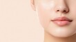 © Jenjira - Close-up of a woman's face with a natural glow, showcasing healthy skin and smooth lips. Perfect for beauty and skincare themes.