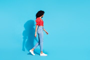 Poster - Full size profile photo of pretty young woman walk empty space wear top isolated on blue color background