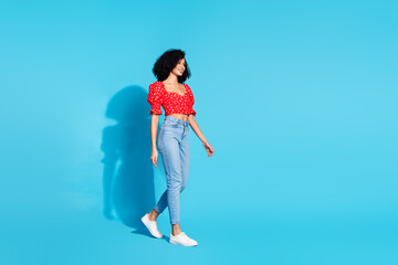 Sticker - Full body profile portrait of gorgeous young woman walk empty space wear top isolated on blue color background