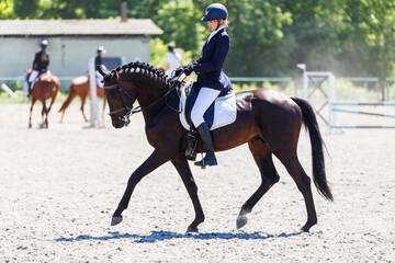 young stressful teenage girl riding horse before her dressage test in equestrian competition