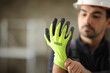 © Antonioguillem - Construction worker putting protective glove before work