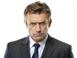 © DigitalArt Max - Concerned middle-aged businessman with a formal suit and worried expression looks directly at the camera, isolated on a plain white studio background.