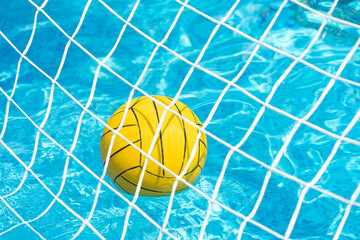 Yellow waterpolo ball on the surface of the water