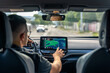 © puhimec - Man touching screen of a GPS navigation system in his car.
