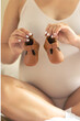 © puhimec - Pregnant woman with big belly holds small shoes for the unborn baby.