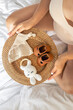 © puhimec - Pregnant woman belly and stylish shoes and toys for baby on white bed at home.